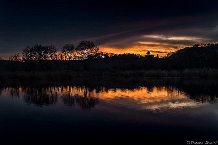 Fotografia di paesaggi al tramonto con riflessi nell'acqua alla riserva naturale torbiere del sebino