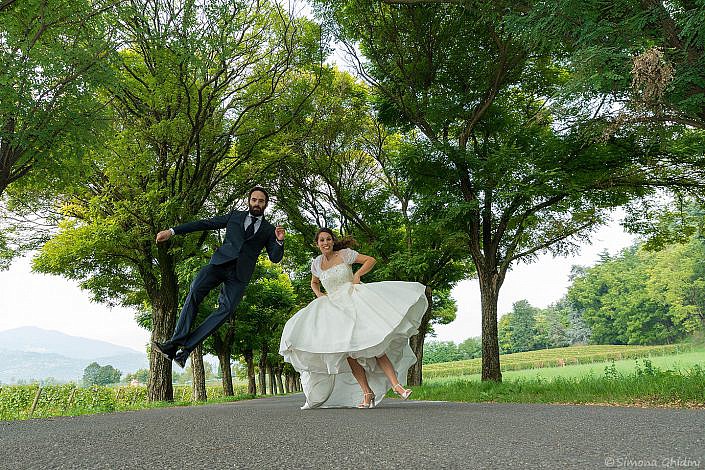 Servizio fotografico per matrimonio con salto degli sposi in viale alberato